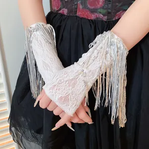 Primo piano di coprimaniche in pizzo bianco con nappe di paillettes argento lucide