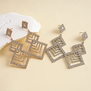 Detail der geometrischen hohlen Ohrringe mit funkelndem Strass-Pavé-Design.