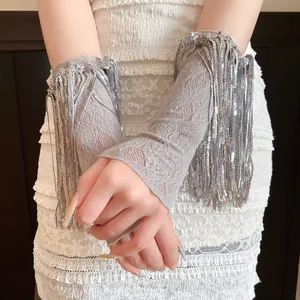 Primo piano di eleganti manicotti in pizzo grigio con frange di paillettes argento lucide.