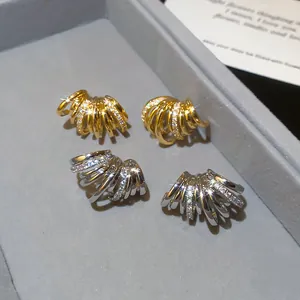 Gros plan détaillé de boucles d'oreilles en C multicouches pavées de zircones brillants