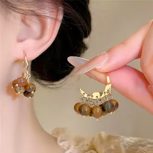 Detailed view of elegant vintage gold hoop earrings with multi-colored brown beads