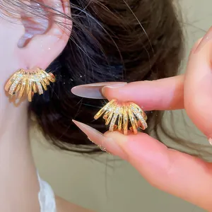 Détail de boucles d'oreilles dorées en C à plusieurs couches avec oxydes de zirconium