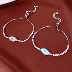 Close-up of two elegant adjustable evil eye bracelets with shiny zircons and shell inlay.