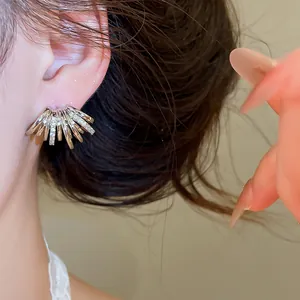 Gros plan de boucles d'oreilles multicouches en forme de C dorées 18 carats.