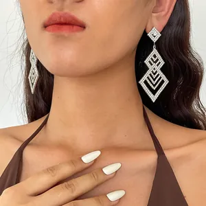 Nahaufnahme von eleganten hohlen geometrischen Silberohrringen mit Diamantbesatz