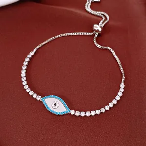 Macro view of silver adjustable tennis bracelet featuring a zircon shell evil eye pendant