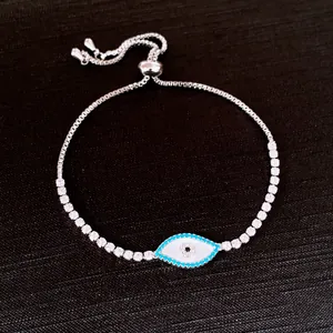 Silver tennis bracelet with a white shell evil eye pendant and adjustable slider clasp