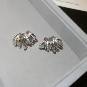 Gros plan de boucles d'oreilles multicouches en forme de C serties de zircons brillants