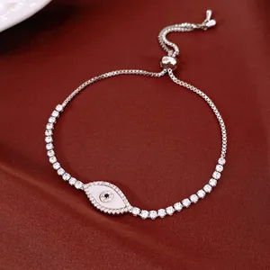 Detailed view of silver evil eye bracelet with shimmering shell inlay and zircon stones
