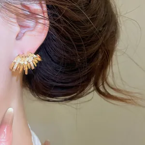 Gros plan d'une boucle d'oreille en C multicouche plaquée or 18 carats avec zircons