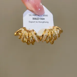 Gros plan de boucles d'oreilles en forme de C plaquées or 18 carats avec détails en zircon.