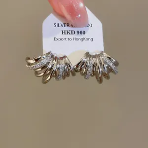 Détail rapproché de boucles d'oreilles multicouches en forme de C plaquées or 18 carats