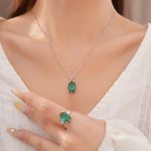 Close-up detail van een elegante groene ovale edelsteen sieradenset met ketting en ring