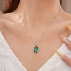 Detailweergave van een elegante halsketting met ovale groene zirkoon hanger aan zilveren