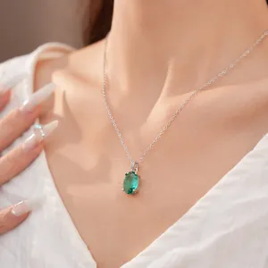 Close-up van een elegante groene ovale zirkoon ketting aan een zilveren ketting
