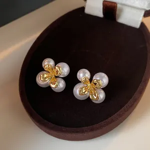 Nahaufnahme von französischen Vintage-Blumenohrsteckern mit weißen Perlen und Goldmitte