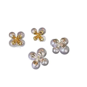 Französische Vintage-Blumen-Perlenohrstecker in Gold und Silber auf weißem Hintergrund