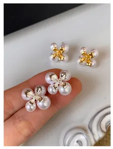 Detailaufnahme von eleganten französischen Vintage-Blumenperlenohrringen in Gold-Optik