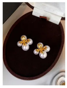 Detailaufnahme französischer Vintage-Blumenohrringe mit eleganten weißen Perlen und Gold