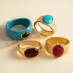 Close-up detail of vintage style gold-tone metal bangles with oval resin stones and a blue resin bracelet