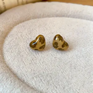 Nahaufnahme der herzförmigen Ohrstecker mit Retro-Leopardenmuster und glänzendem Finish