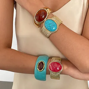 Close-up showing four vintage style resin and metal oval bangles worn on a model arm