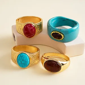 Detailed view of vintage metal and resin bangles with oval stones on a geometric prop