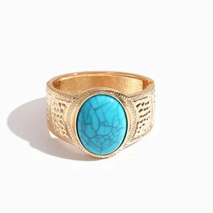 Vintage gold-plated metal bracelet featuring a large oval faux turquoise stone.