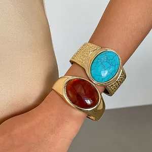 Close-up detail of vintage gold cuff bracelets with turquoise and amber resin stone inserts