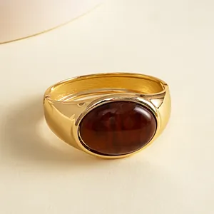 Detailed macro view of a vintage gold metal bangle with marbled oval resin stone