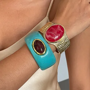 Close-up detail of textured gold-tone and turquoise resin marble pattern chunky bangles