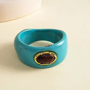 Close-up of vintage marbled teal resin bangle with an oval dark brown center stone