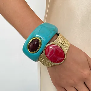 Detail shot of vintage resin and gold metal cuff bracelets with marbled oval stones.