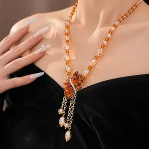 Close-up detail of a vintage beaded necklace featuring a rhinestone flower and water drop tassels