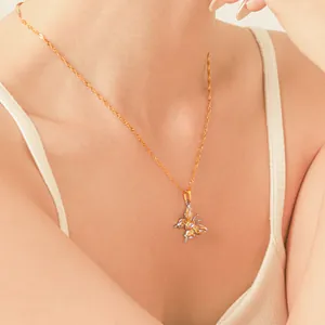 Close-up of a two-tone stainless steel butterfly pendant necklace with zircon on a model.