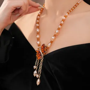 Close-up detail of vintage amber beaded necklace with elegant tassel and rhinestones