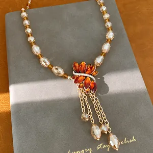 Macro detail of vintage beaded necklace with rhinestone floral pendant and tassels