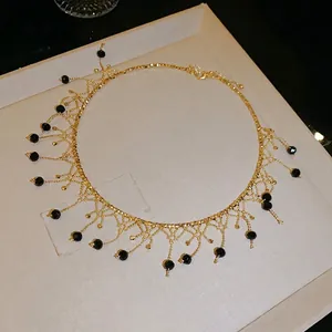 Gargantilla dorada elegante con colgantes de cristal negro y diseño de encaje retro