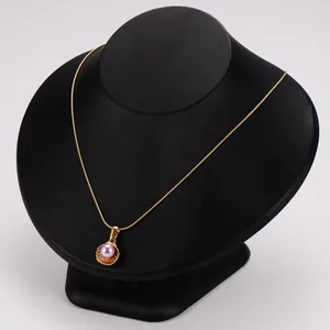 Detail view of an elegant stainless steel shell pendant necklace with a purple pearl