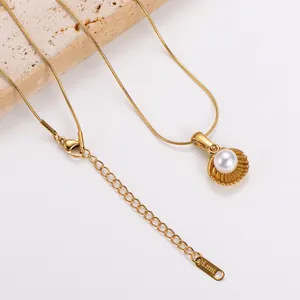 Detailed macro view of a gold stainless steel shell pendant necklace with a white pearl