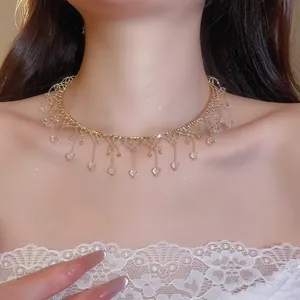 Détail d'un collier ras de cou élégant avec pampilles en cristal et dentelle dorée.
