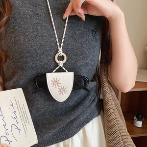 Gros plan d'un collier porte-lunettes de soleil en cuir vintage avec broderie de soleil
