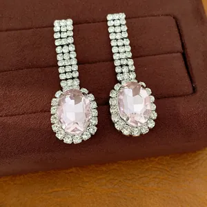 Nahaufnahme eleganter rosa ovaler Ohrhänger mit funkelnden Strasssteinen und Fransen