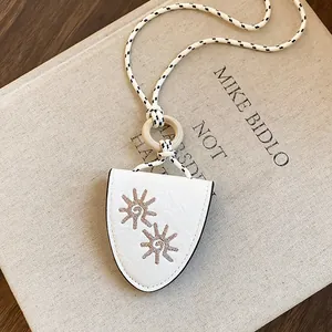 Vue détaillée du collier avec clip pour lunettes de soleil en cuir brodé tournesol