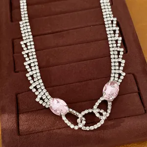 Nahaufnahme einer luxuriösen Halskette mit rosa Edelsteinen auf Samttablett.