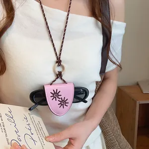 Gros plan d'un collier porte-lunettes de soleil en cuir rose sur un haut blanc chic