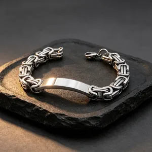 Close-up of a polished stainless steel Byzantine chain bracelet with an engraving plate