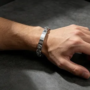 Detail view of a men's stainless steel Byzantine chain bracelet with a blank ID plate