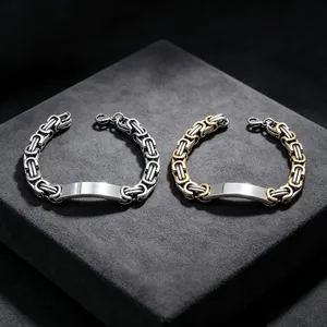 Close-up of men's Byzantine chain bracelets with engravable ID bars in silver and gold