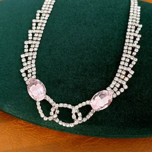 Nahaufnahme einer eleganten Halskette mit rosa ovalen Edelsteinen und glänzendem Strass